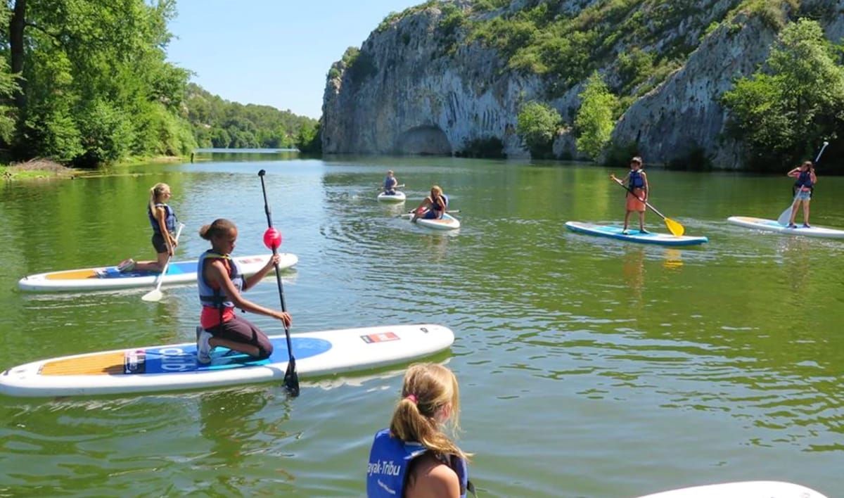 Paddleboarders on the calm green water of the Gardon gorges